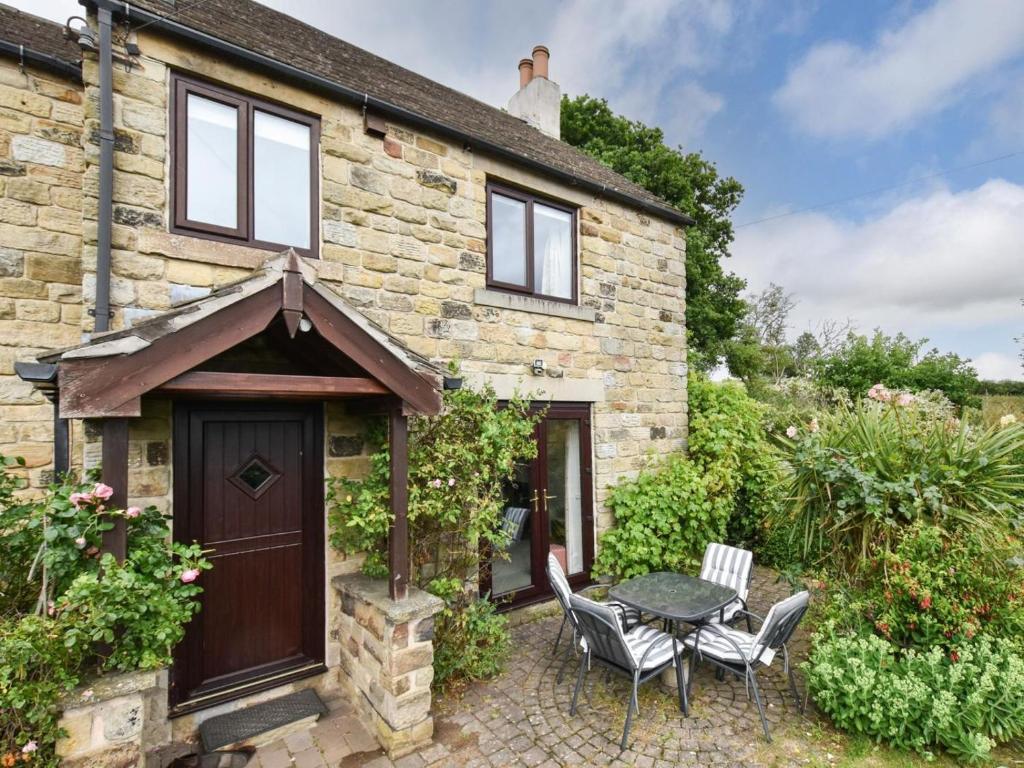 a stone house with a table and chairs in front of it at 2 Bed in Holmesfield oc-pk783 in Dronfield