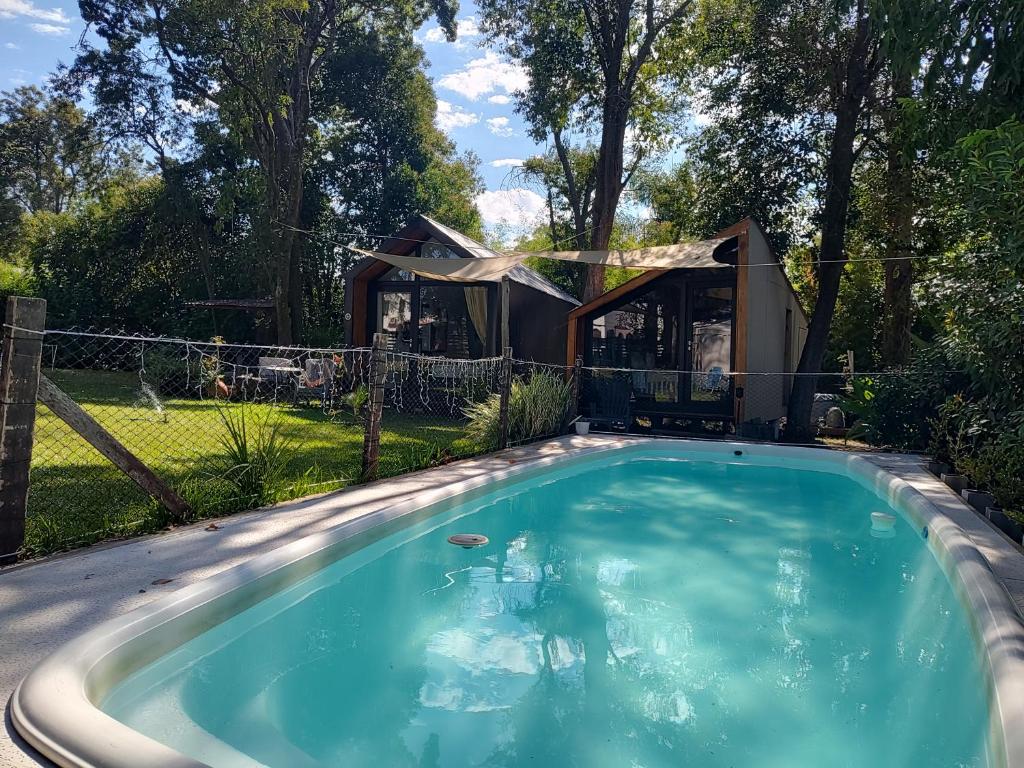a swimming pool in a backyard with a house at Refugios de Rio Ilo in Concepción del Uruguay