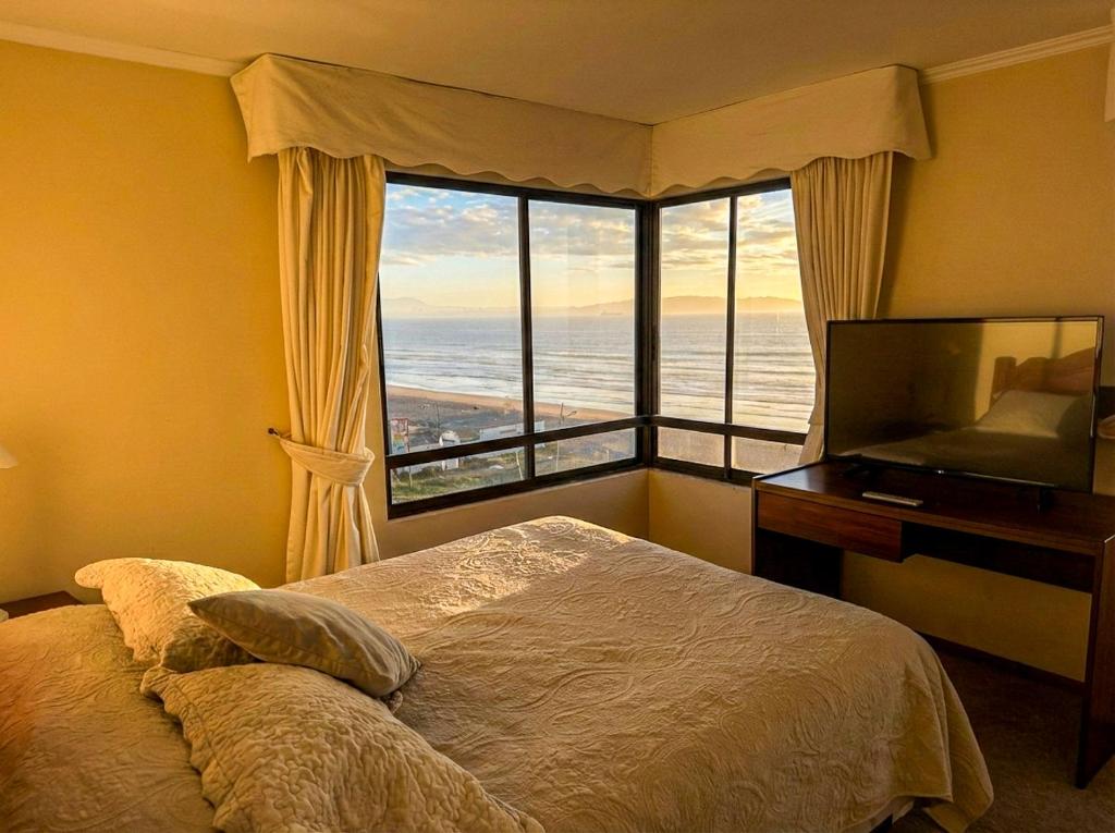 a bedroom with a bed and a large window at Departamento La Serena Vista al Mar in La Serena