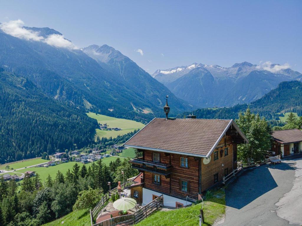 a house on a hill with mountains in the background at Poschen in Wald im Pinzgau