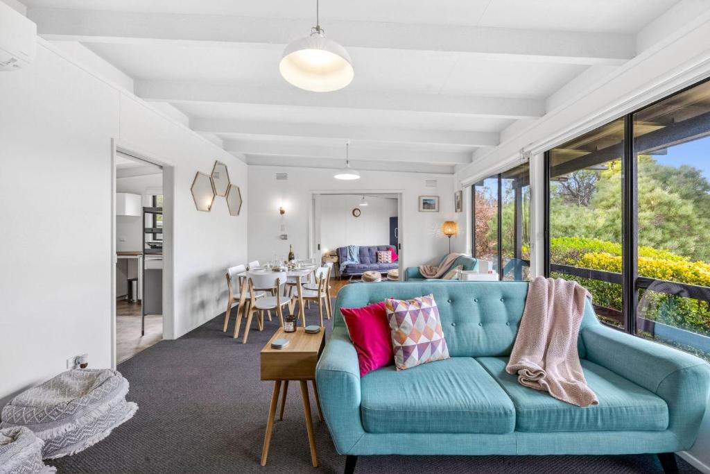 a living room with a blue couch and a table at Oceanside Escape in Aireys Inlet
