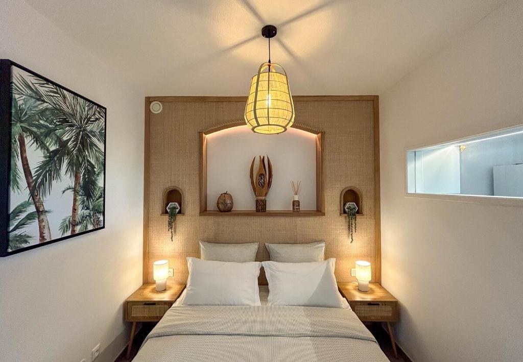 a bedroom with a bed with two lamps and a mirror at Palm Beach Studio - New Beach Residence in Saint Martin