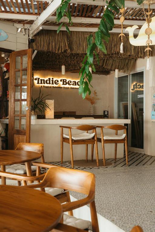 a restaurant with wooden tables and chairs and a counter at Indie Beach Koh Chang in Ko Chang