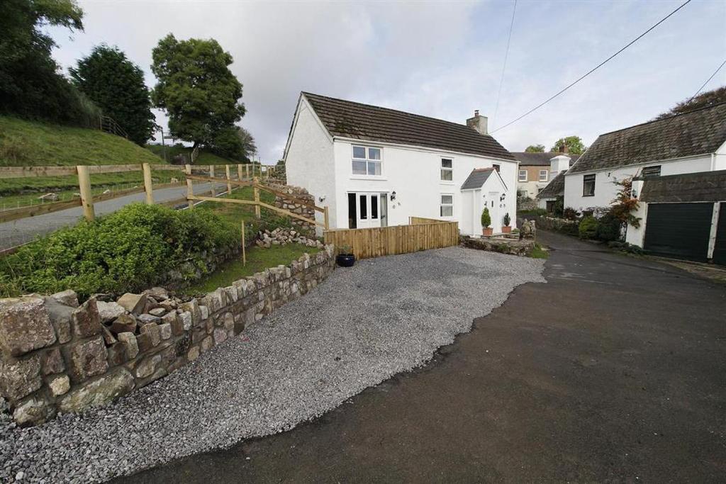 a white house with a stone wall and a driveway at 3 Bed in Swansea oc-hh405 in Llanmadoc
