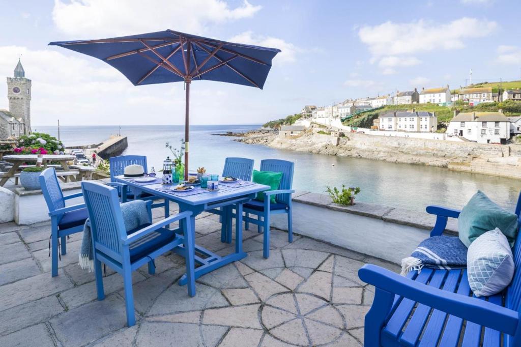 a blue table with chairs and an umbrella on a patio at 3 Bed in Porthleven oc-12bayv in Porthleven