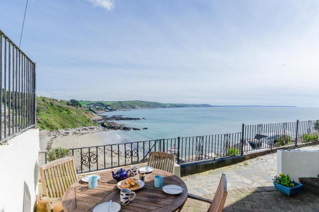 a wooden table on a balcony with a view of the ocean at 2 Bed in Looe oc-l10082 in Looe