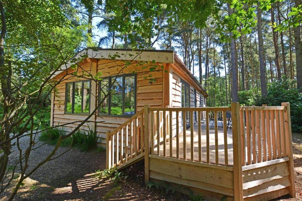 a wooden cabin in the woods with a wooden fence at 2 Bed in Weybourne oc-1628 in Kelling