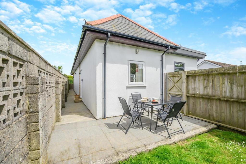 a patio with a table and chairs next to a fence at 2 Bed in Padstow oc-p00398 in Saint Merryn