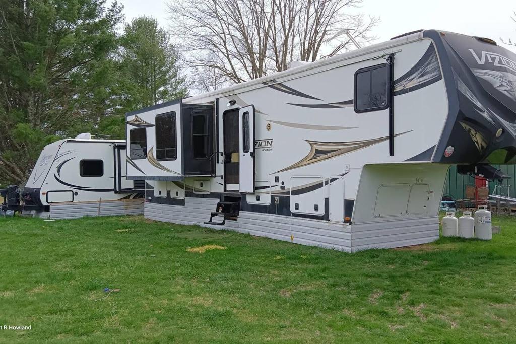 an rv parked on the grass in a field at Mountain Camper at Howland's Hideout in Sampson