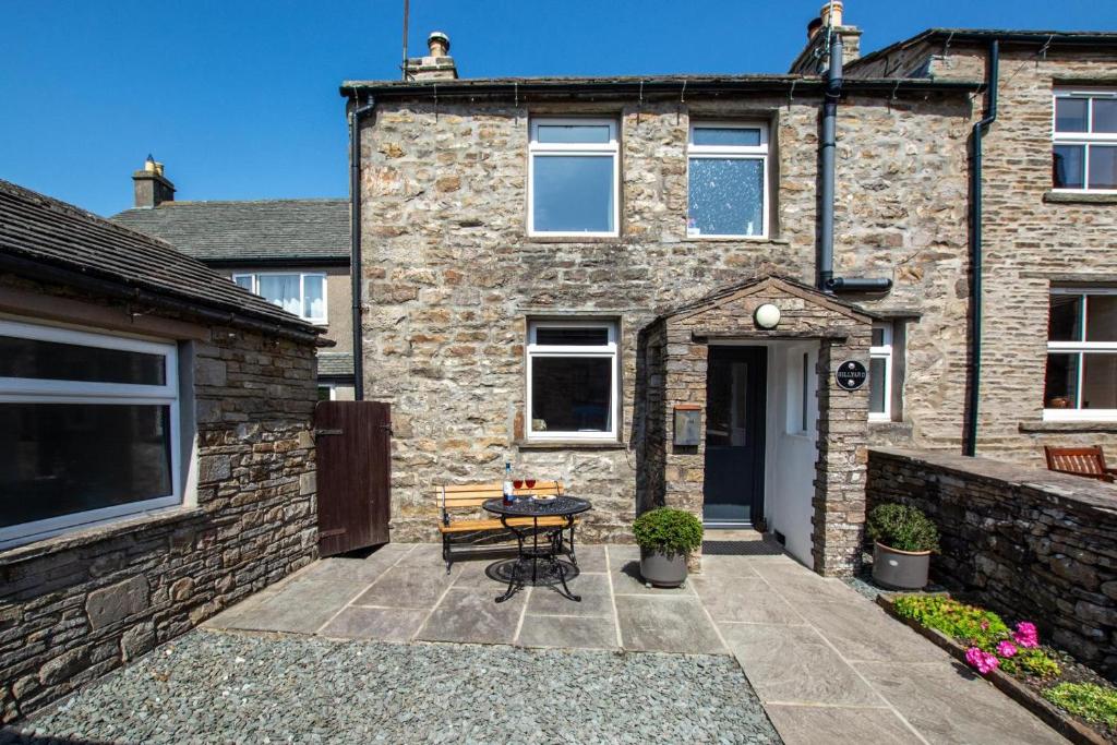 a patio in front of a brick house with a table at 2 Bed in Gayle oc-ds912 in Hawes