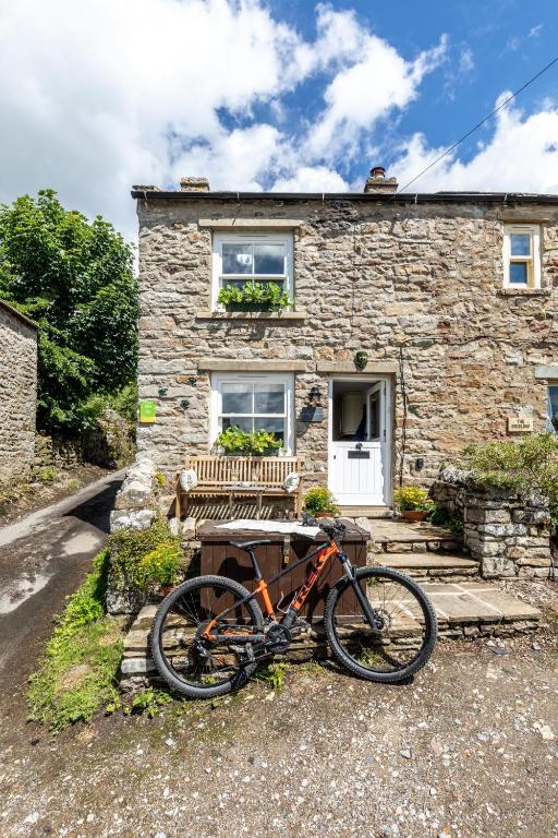 Ein Fahrrad, das vor einem Steinhaus geparkt ist in der Unterkunft 2 Bed in High Fremington oc-ds375 in Reeth