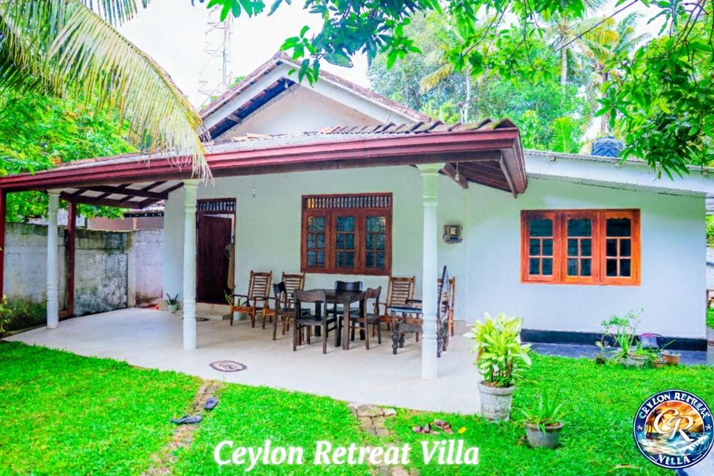a house with a patio with a table and chairs at Ceylon Retreat Villa in Kamburugamuwa