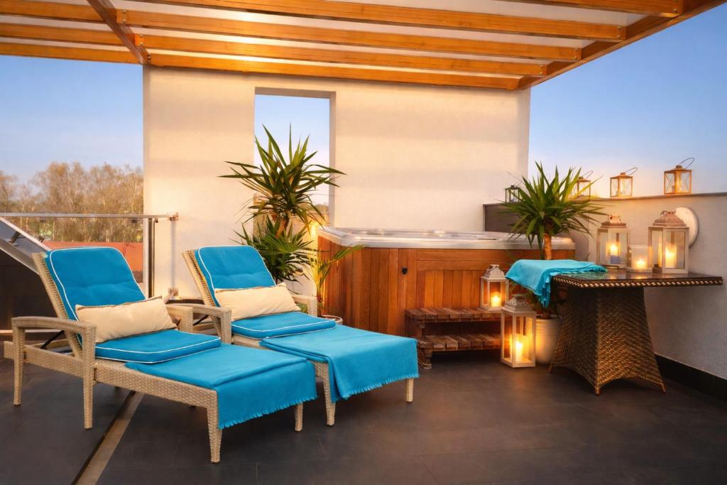 a patio with blue chairs and a table at HOTEL Amber Suite & SPA - Enklawa dla Dorosłych in Międzywodzie