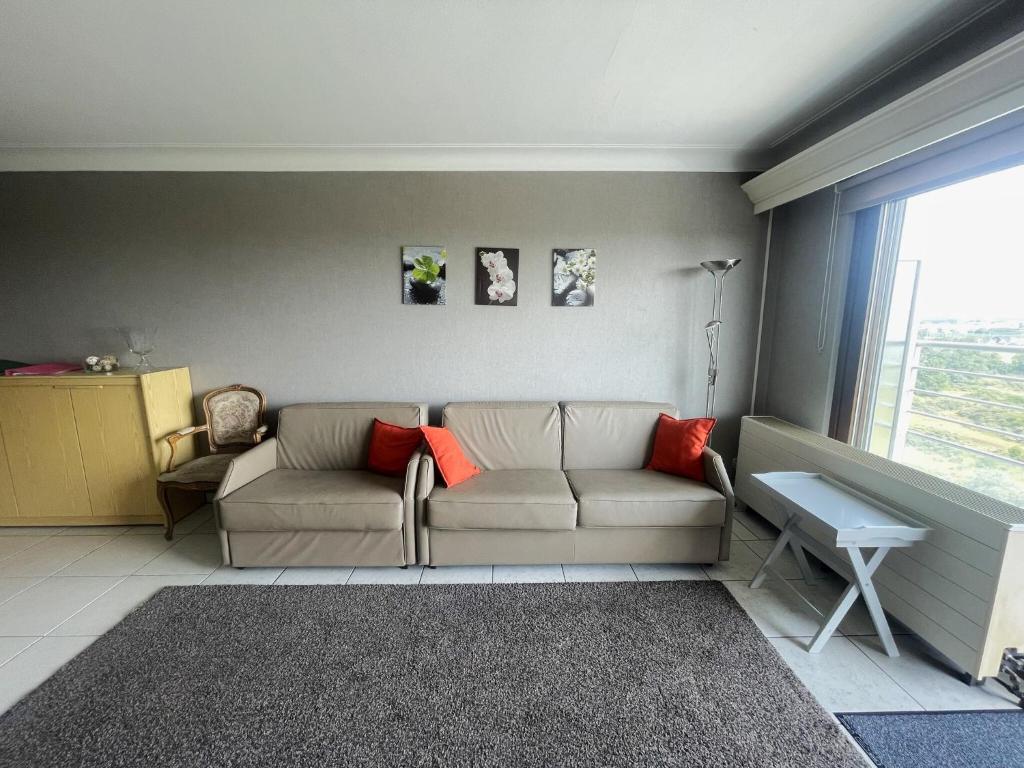a living room with a couch and a window at Apartment with Pool and Sea View in Middelkerke
