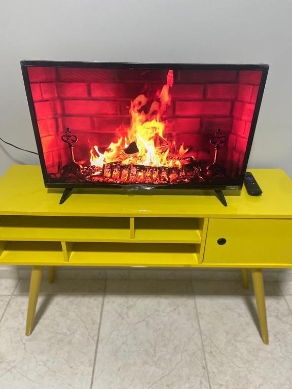 a tv sitting on a table with a fire in it at Seja Bem-Vindos, sinta-se em Casa ! in São Lourenço