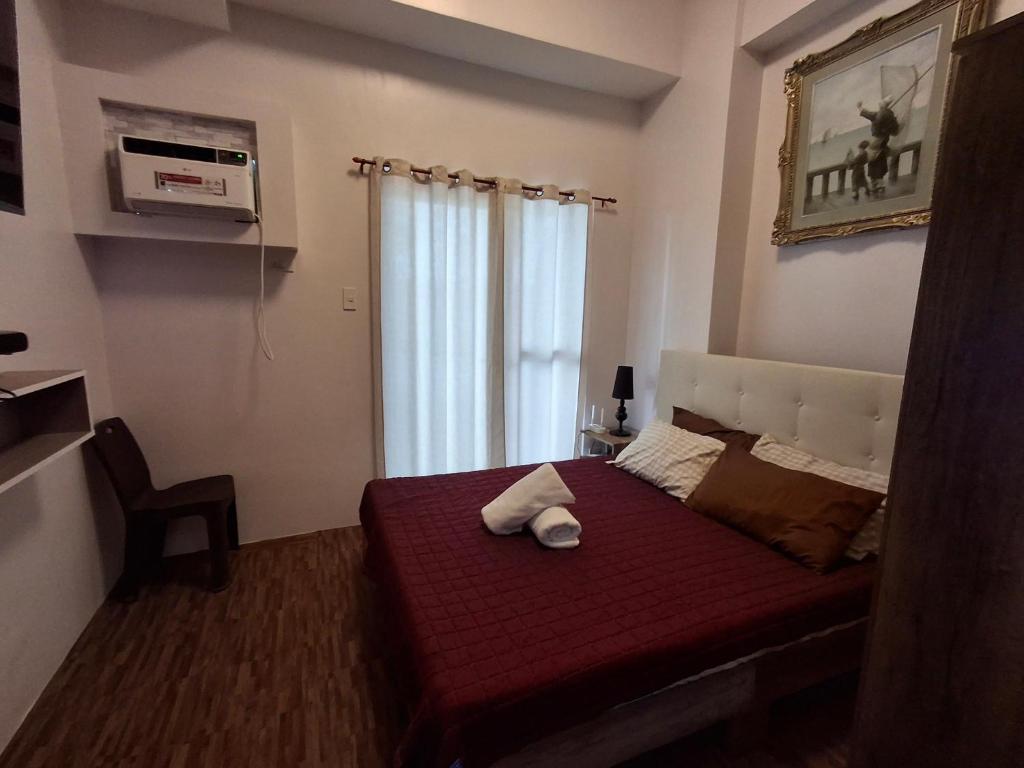 a bedroom with a red bed with a window at Casa Aurora in Mandaue City