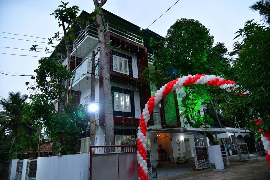 a red and white arch in front of a building at Orchid Woods in Trivandrum