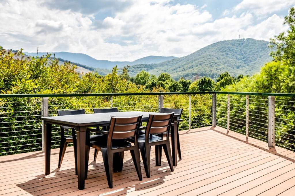 a table and chairs on a deck with a view of mountains at Cindy's View in Bright