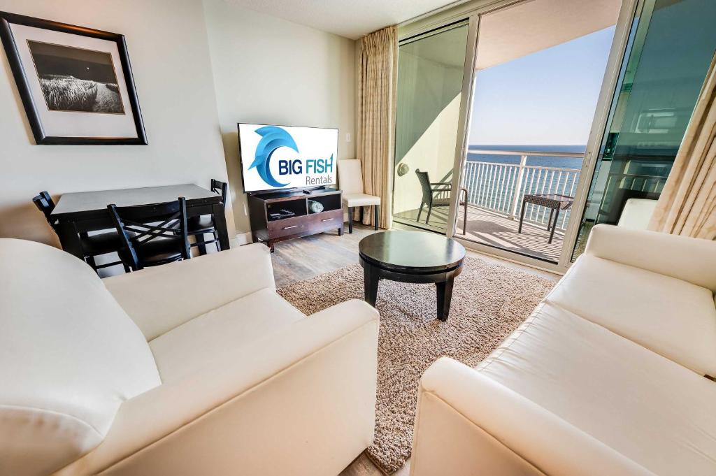 a living room with a white couch and a television at Romantic Honey Moon Suite, Direct Oceanfront,Pools in Myrtle Beach