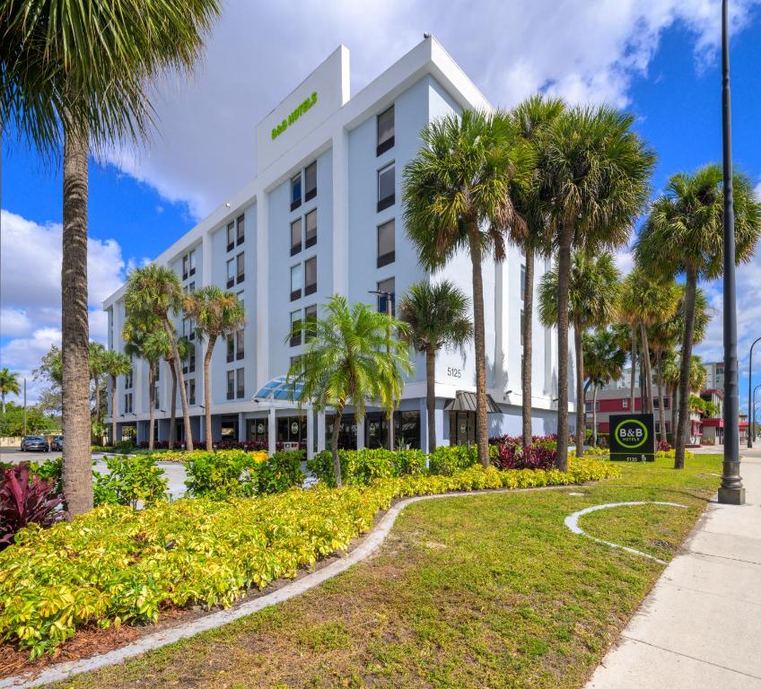 a hotel with palm trees in front of a building at B&B Hotel Miami Airport in Miami