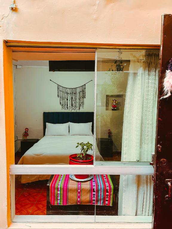 a bedroom with a bed and a table with a plant at Ñusta Wasi in Cusco