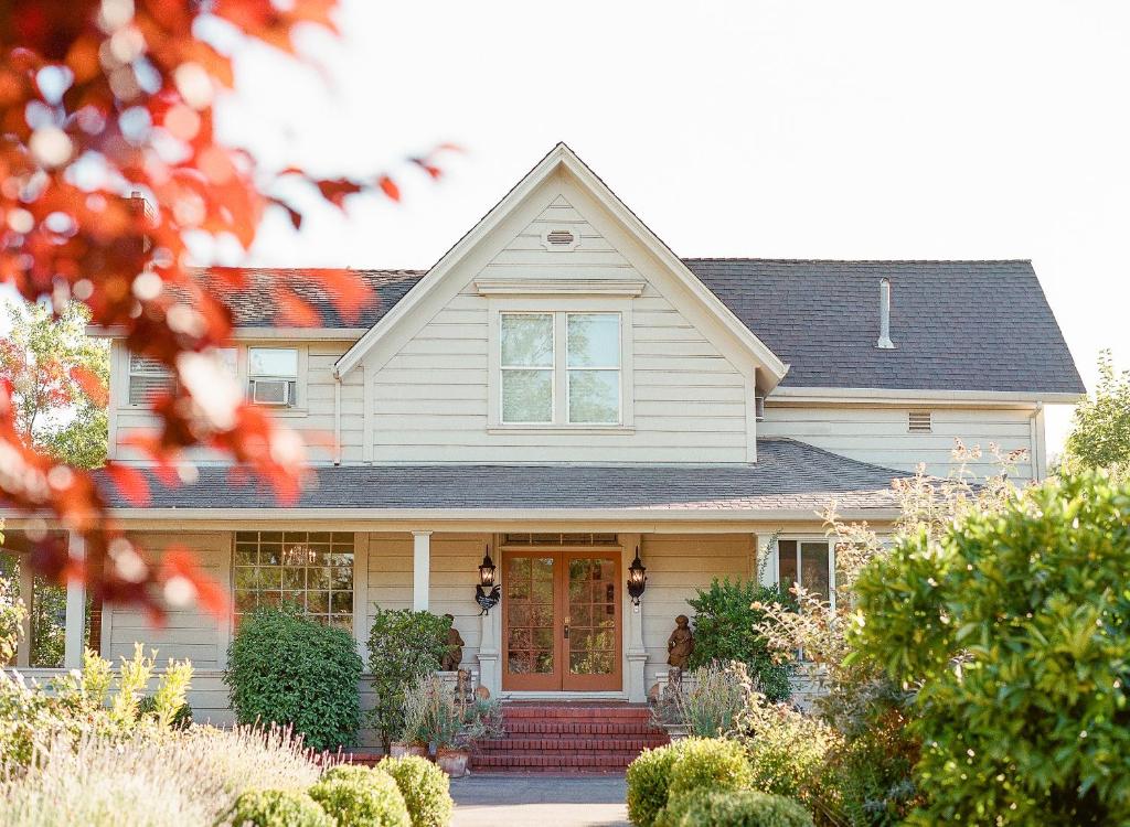 a white house with a red door at Napa Farmhouse Inn in St. Helena