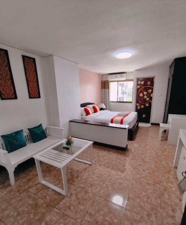 a bedroom with a bed and a couch and a table at Noble Place Chiangmai in Chiang Mai