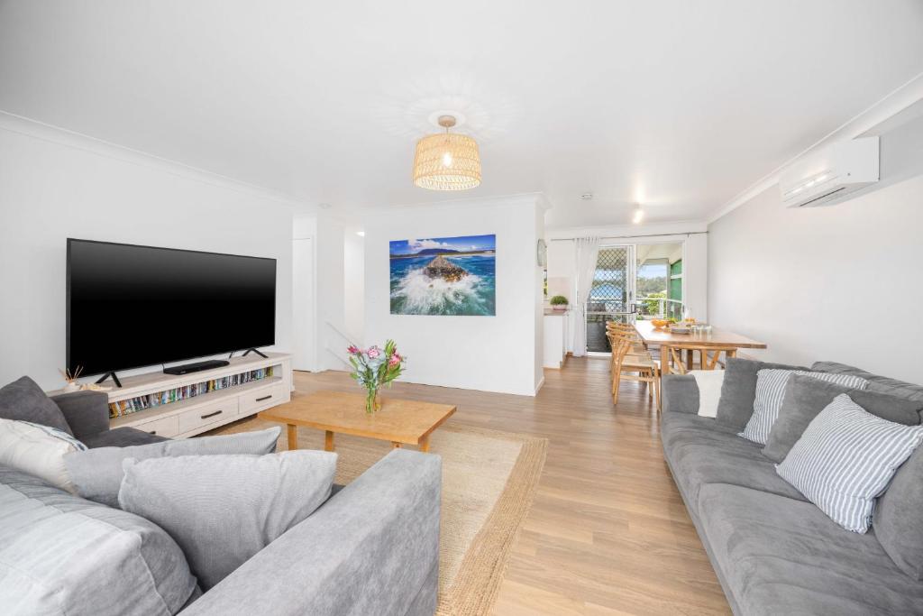 a living room with a couch and a flat screen tv at Alma Beach Haven in North Haven