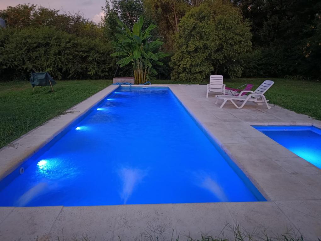 a blue swimming pool with two lawn chairs next to it at la morita silvestre in General Rodríguez