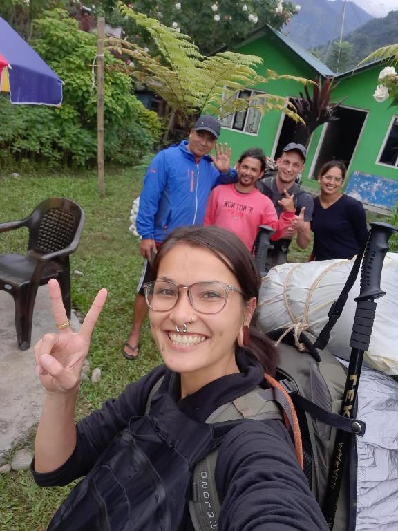 Eine Frau, die mit dem Finger das Friedenszeichen zeigt. in der Unterkunft Riverside hostel in Ghanpokhara