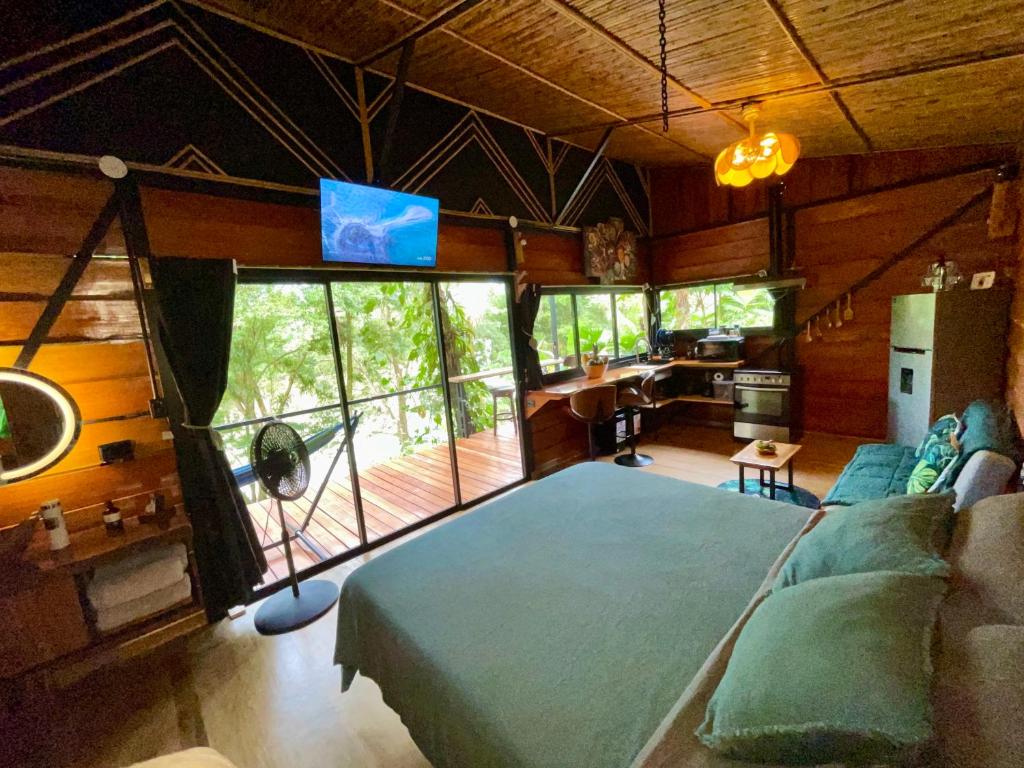 a bedroom with a large bed and a living room at Cabaña Río San Carlos Ecolodge in Boca Tapada