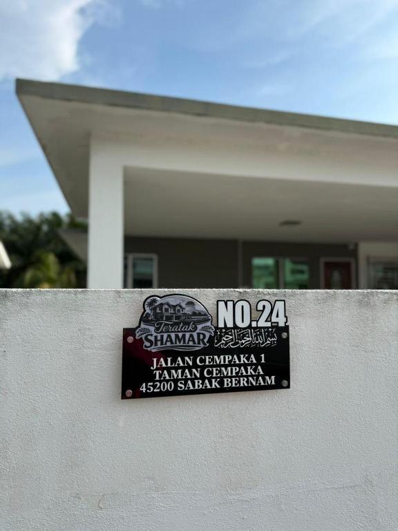 a sign on a wall in front of a house at Teratak Shamar in Kampong Tebok Pulai