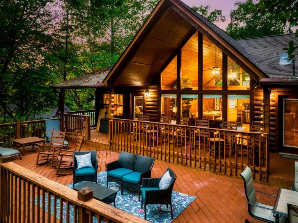 a house with a deck with chairs and tables at Joy's Retreat Cabin in Sevierville