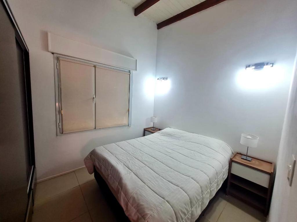 a bedroom with a bed and two lights on the wall at Viedma in Viedma
