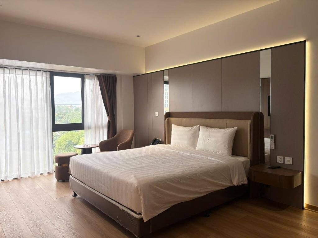 a bedroom with a large bed and a large window at ASEAN MINH NGUYỆT Hotel in Nhân Mỹ