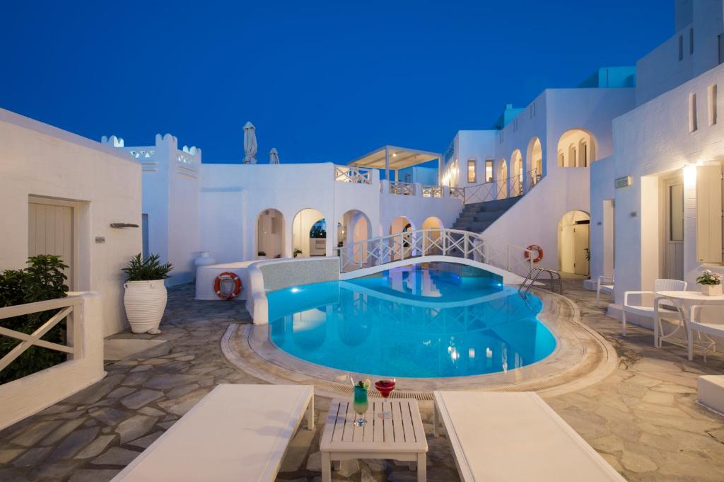 a villa with a swimming pool at night at Kanale's Rooms & Suites in Naousa
