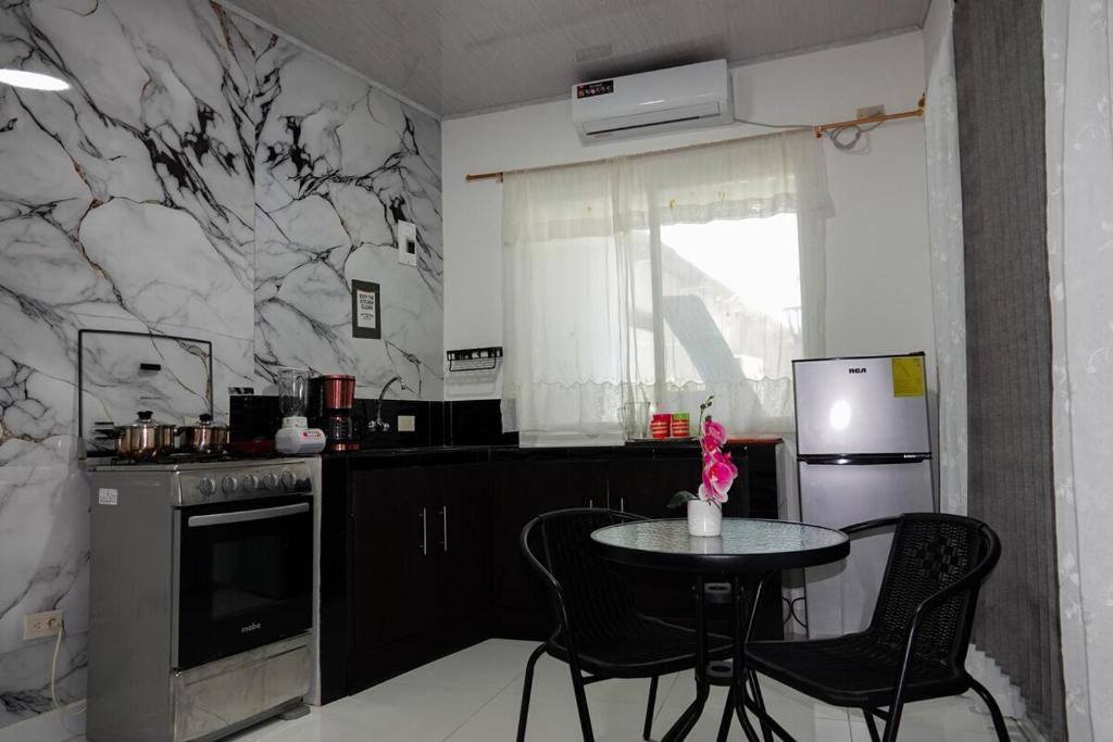 a kitchen with a table with chairs and a refrigerator at San Cristóbal Surf House II in San Cristóbal