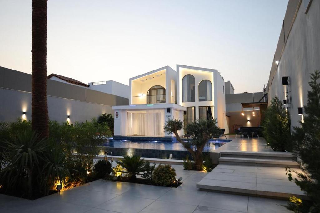 a villa with a swimming pool and a building at Amora Villa in Al Rama