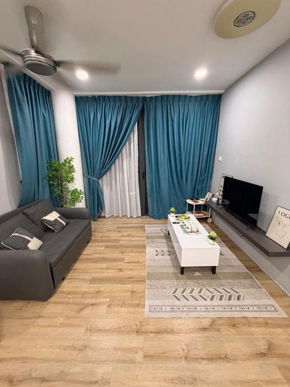 a living room with a black couch and a tv at Hann's Residence Your second home in Sibu
