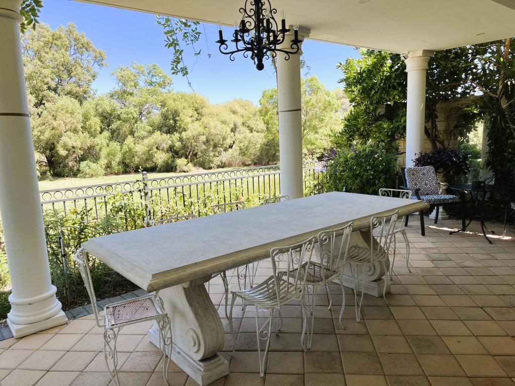 a table and chairs sitting on a porch at River Suite Studio with Lovely Garden - Walk to River in Perth