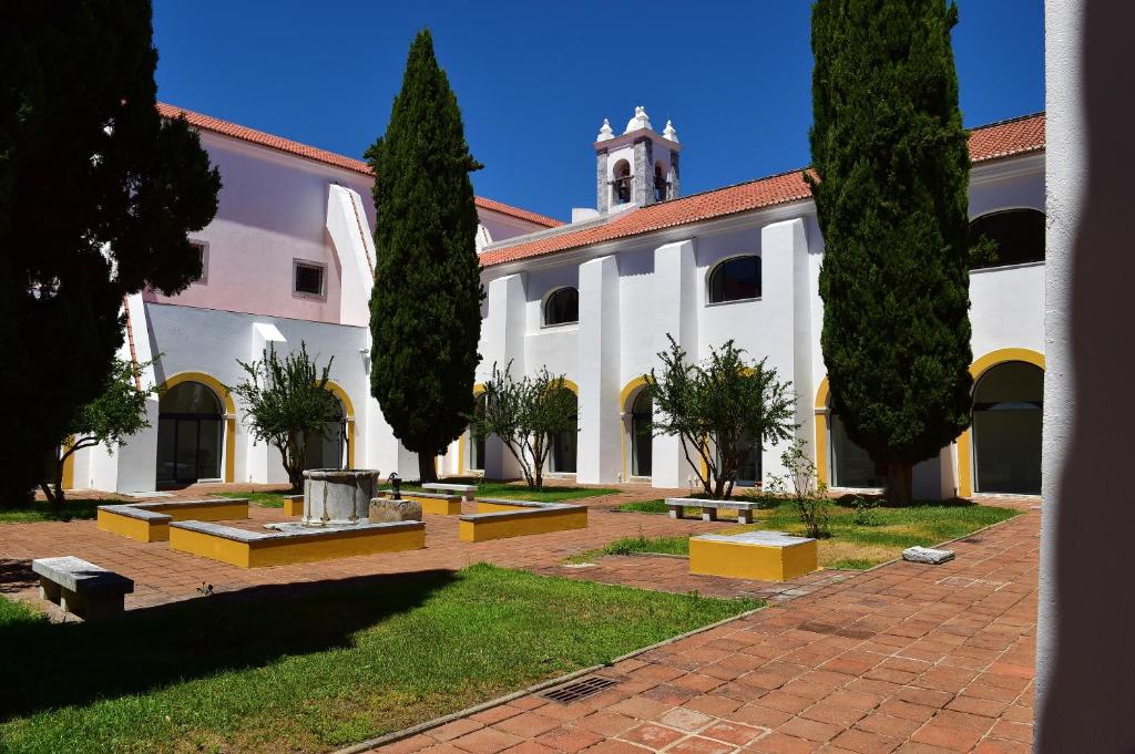 a large white building with trees in front of it at Pousada Convento de Beja in Beja