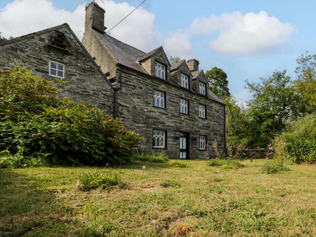 an old stone house on a grass field at Cynfal Fawr in Blaenau-Ffestiniog