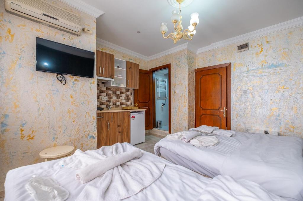 a bedroom with two beds and a tv on the wall at suites beyazıt in Istanbul