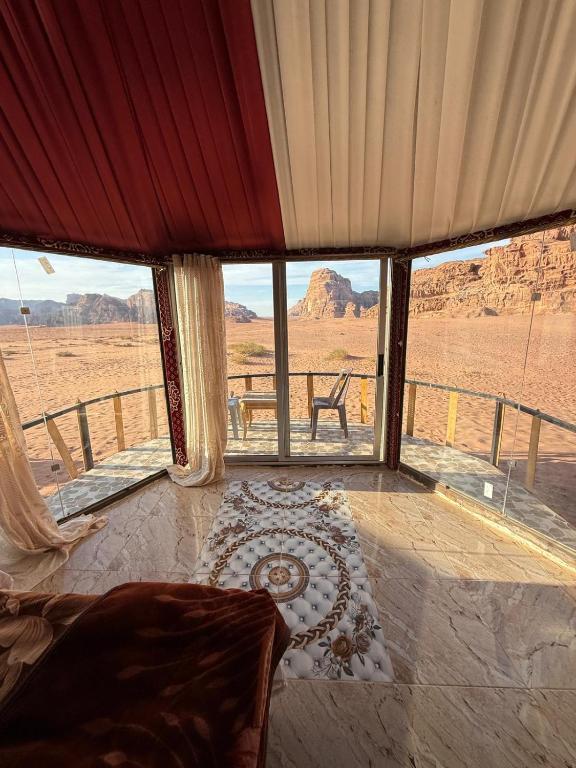 a bedroom with a view of the desert through windows at joy of life Camp in Wadi Rum