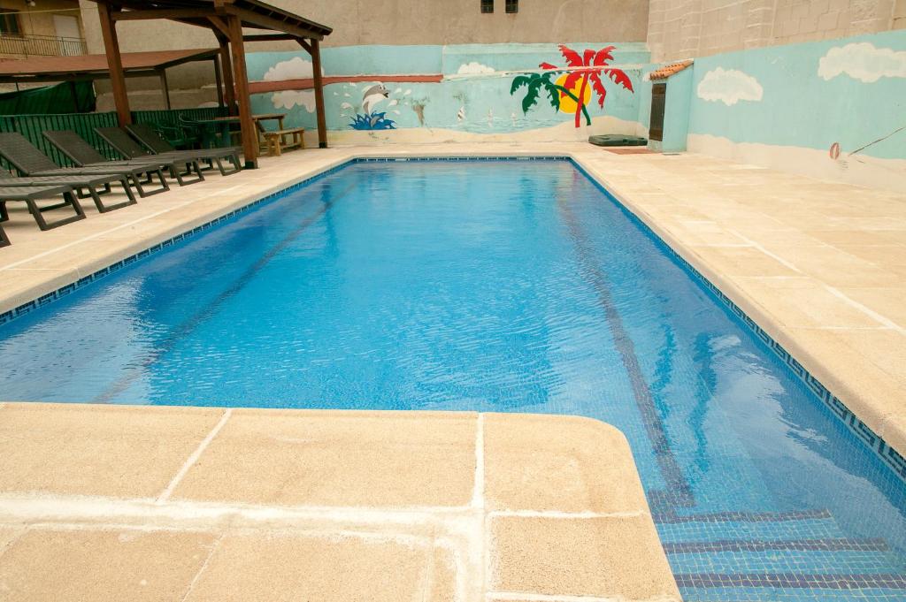 a large blue swimming pool in a building at La Tahona Vieja in El Barraco