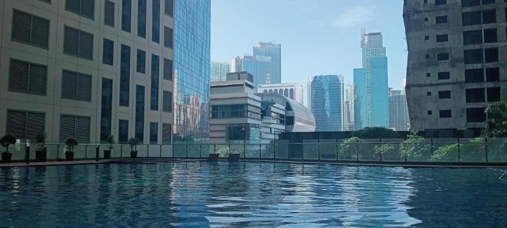 a large pool of water in a city with tall buildings at Knightsbridge Residences with Free Pool, Sauna, Fast WiFi, Gym and Kitchen in Manila