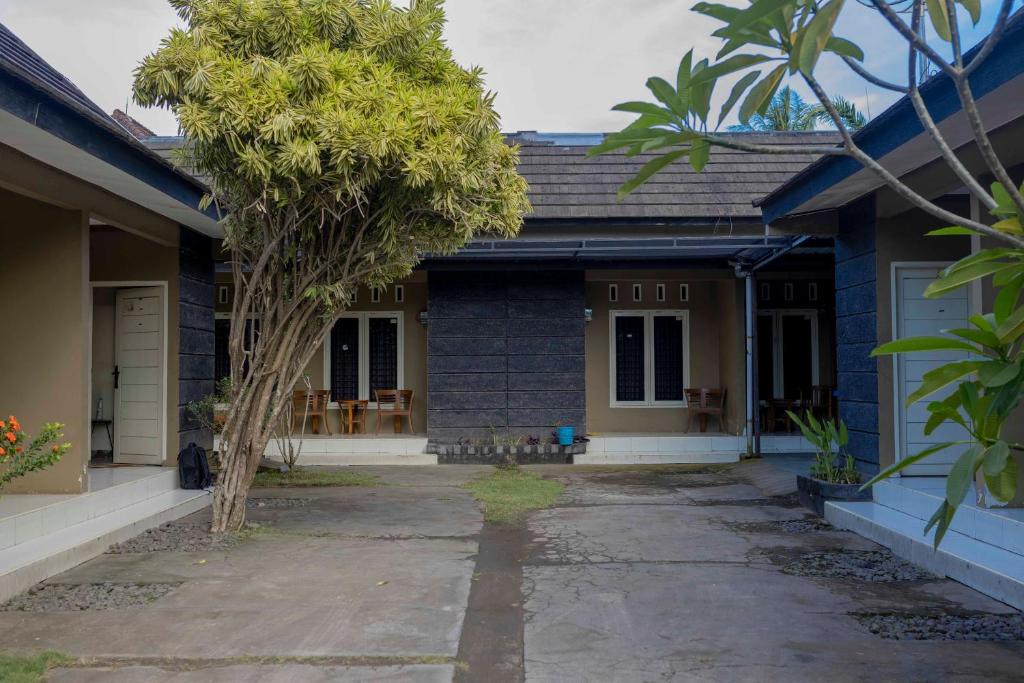 a blue house with a tree in front of it at Sandik Local Stay in Midang