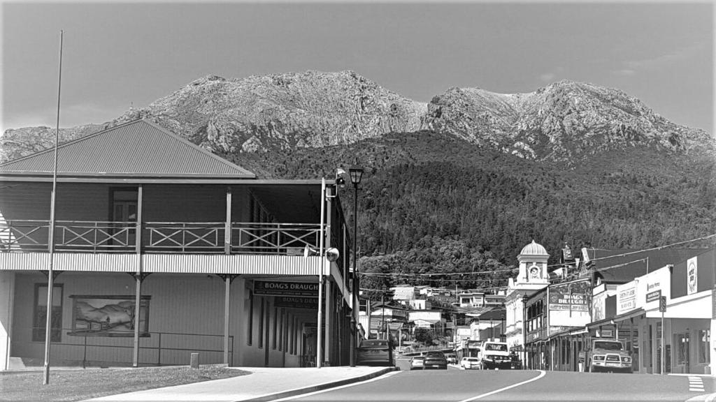 a black and white photo of a town with mountains at Mt Lyell Motor Inn - By Orangepete in Queenstown