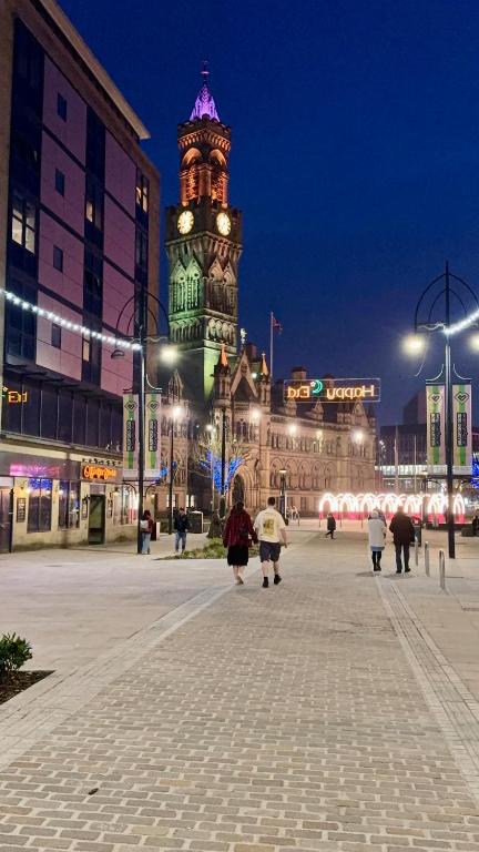 a large building with a clock tower at night at 2 Spacious Double Bedroom Apartment - Bradford in Bradford