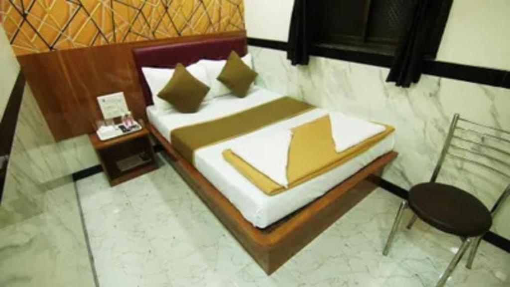 a bedroom with a bed and a chair at FabHotel Star Hill in Mumbai